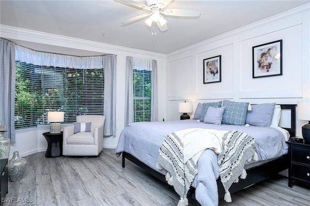 bedroom with ceiling fan, crown molding, and light wood-type flooring