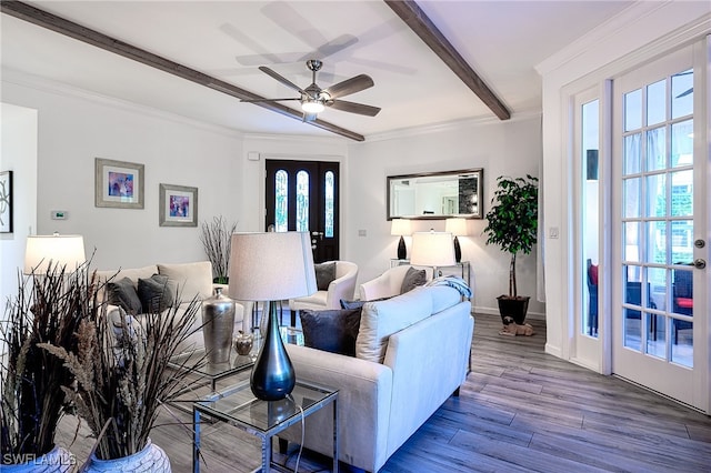 living room with a wealth of natural light, beamed ceiling, wood-type flooring, and ceiling fan