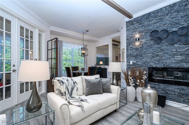 living room featuring beamed ceiling, ornamental molding, a notable chandelier, and hardwood / wood-style flooring