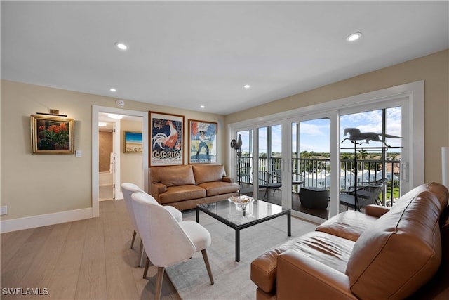 living room with light wood-type flooring and a water view