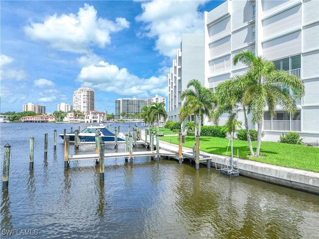 dock area with a water view, a view of city, and a lawn