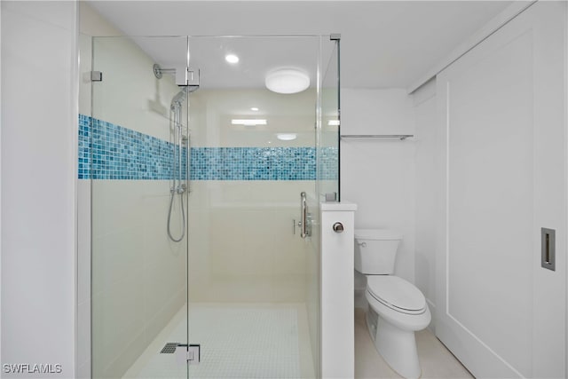 bathroom featuring tile patterned floors, toilet, and an enclosed shower