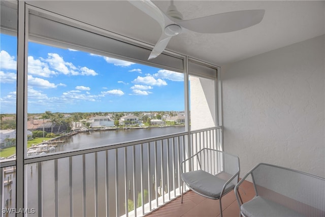 balcony featuring ceiling fan and a water view