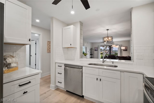 kitchen with tasteful backsplash, stainless steel appliances, sink, light hardwood / wood-style flooring, and white cabinetry