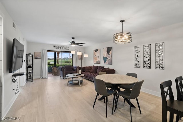 12170 Kelly Sands Way Unit 702, Fort Myers, FL 33908 - dining room featuring light wood-style floors, a ceiling fan, baseboards, and a chandelier