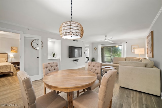 dining space featuring ceiling fan, wood-type flooring, and crown molding