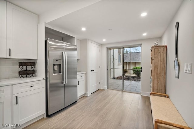 12540 Kelly Greens Blvd Unit 327, Fort Myers, FL 33908 - kitchen with stainless steel fridge, light wood-type flooring, white cabinets, backsplash, and recessed lighting