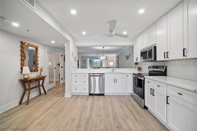 kitchen featuring white cabinets, stainless steel appliances, and light hardwood / wood-style floors