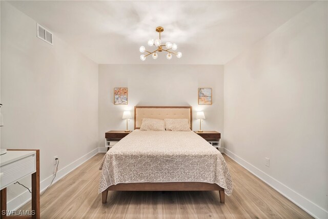 bedroom featuring light hardwood / wood-style floors and a notable chandelier