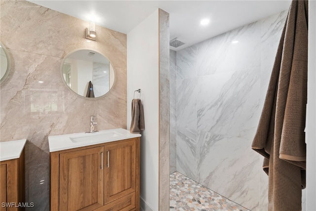 bathroom featuring vanity, a shower, and tile walls