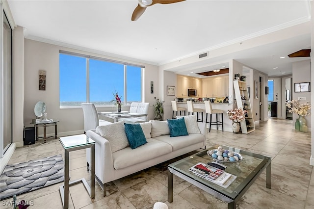 living room with ceiling fan and ornamental molding