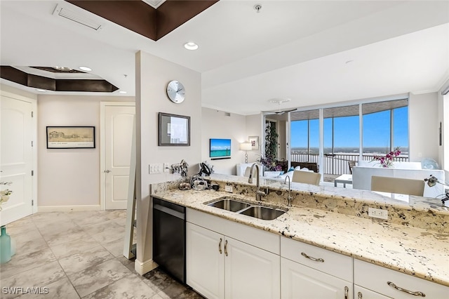 kitchen with stainless steel dishwasher, light stone counters, white cabinetry, and sink