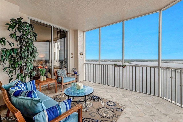 sunroom with a beach view and a water view