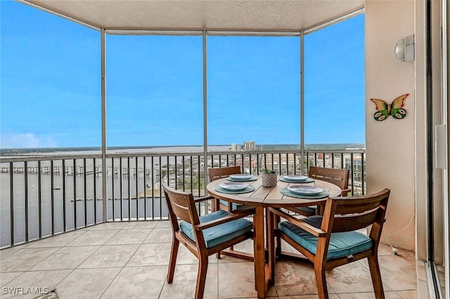 sunroom / solarium featuring a view of the beach and a water view