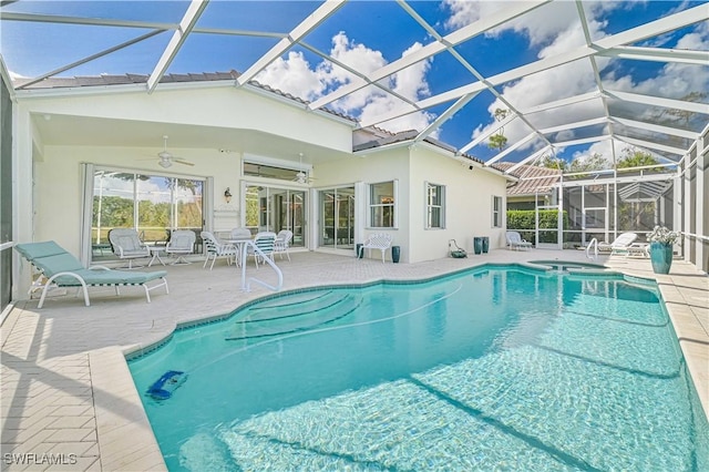 view of swimming pool with a lanai, ceiling fan, a patio area, and an in ground hot tub