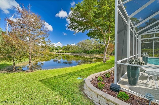 view of yard featuring glass enclosure and a water view