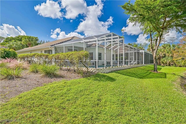 rear view of house with a lanai and a lawn