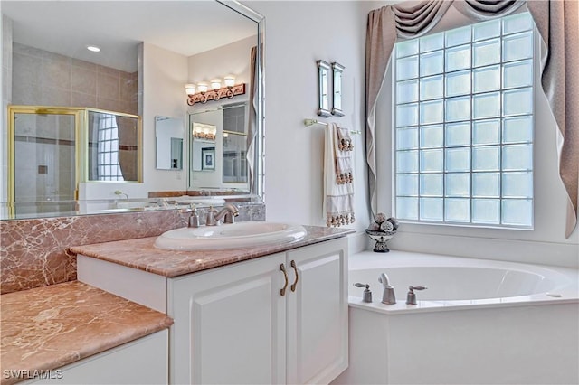 bathroom with vanity and independent shower and bath