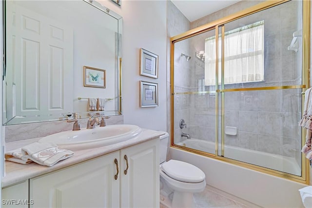 full bathroom featuring combined bath / shower with glass door, vanity, toilet, and tile patterned flooring