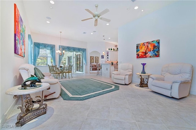 tiled living room featuring ceiling fan with notable chandelier