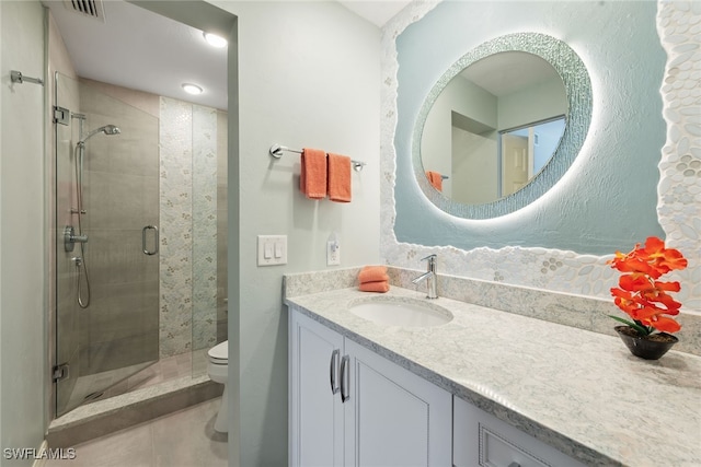 bathroom featuring toilet, an enclosed shower, and vanity