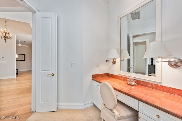 bathroom featuring hardwood / wood-style flooring, ceiling fan with notable chandelier, and vanity