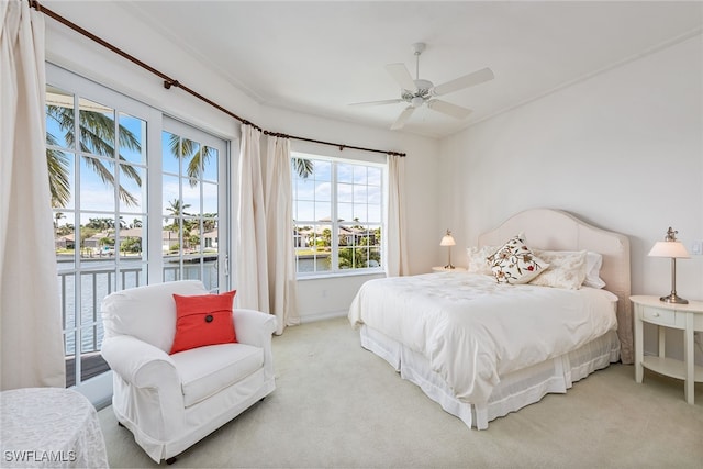 carpeted bedroom with a water view and ceiling fan