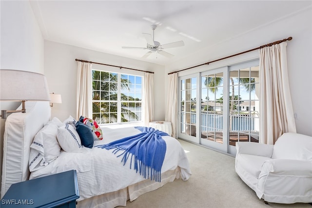 carpeted bedroom with ceiling fan, a water view, and access to outside