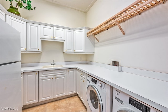 laundry area with sink, independent washer and dryer, and light tile patterned floors