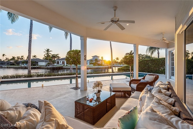 sunroom with a water view and ceiling fan