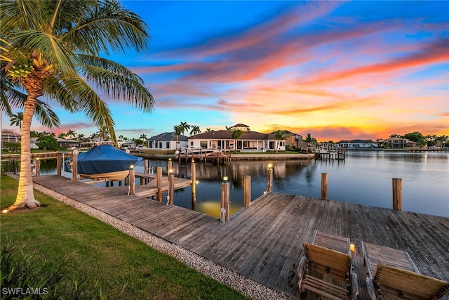 view of dock with a yard and a water view