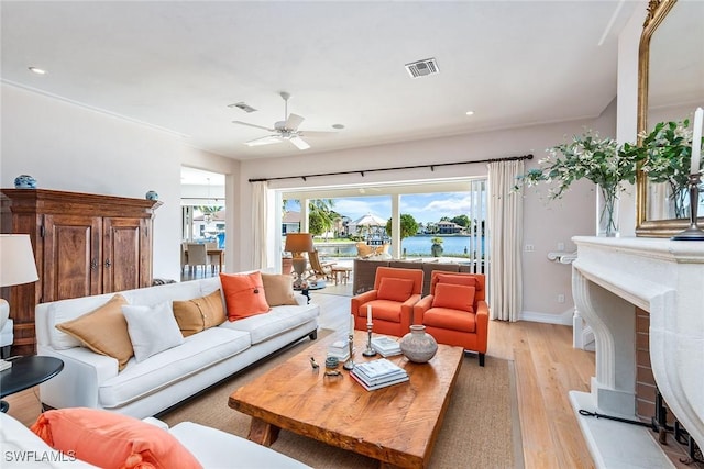 1627 Barbados Ct, Marco Island, FL 34145 - living room with light wood-style floors, a ceiling fan, recessed lighting, a water view, and a fireplace