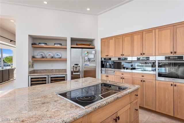 kitchen with appliances with stainless steel finishes, light stone counters, and light tile patterned flooring