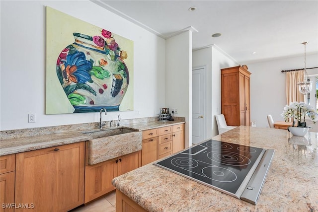 1627 Barbados Ct, Marco Island, FL 34145 - kitchen featuring black electric cooktop, hanging light fixtures, crown molding, a chandelier, and light stone countertops