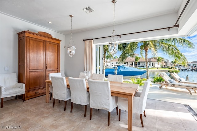 dining space featuring a water view, light tile patterned floors, and a notable chandelier