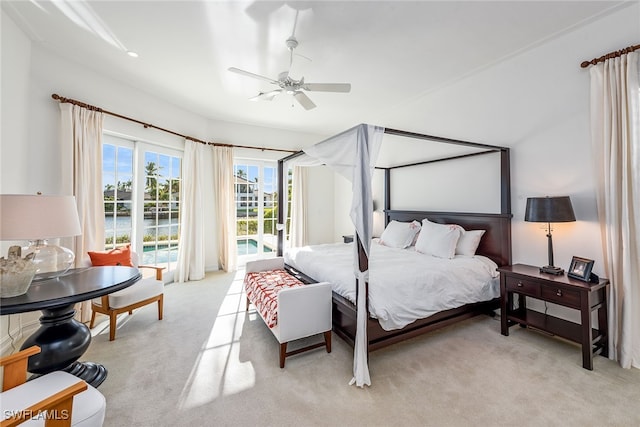 bedroom with ceiling fan, a water view, and light colored carpet