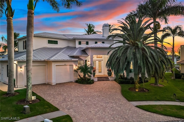 view of front of house with a garage and a lawn