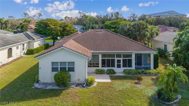 back of property featuring a patio and a lawn