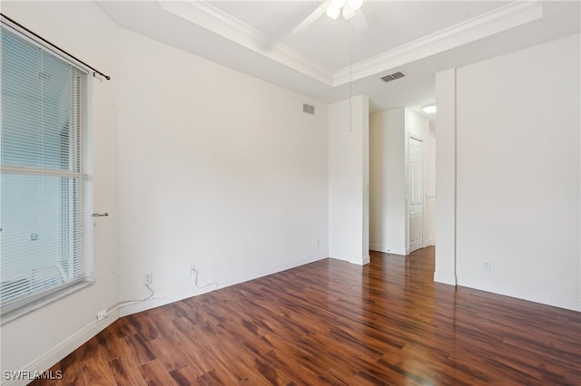 unfurnished room featuring dark hardwood / wood-style floors, ceiling fan, a raised ceiling, and crown molding