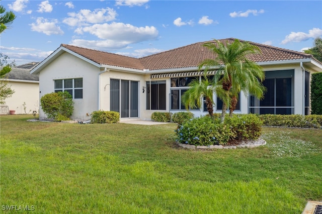 rear view of house featuring a sunroom and a yard