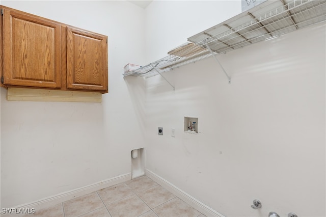 washroom featuring electric dryer hookup, gas dryer hookup, cabinets, washer hookup, and light tile patterned flooring