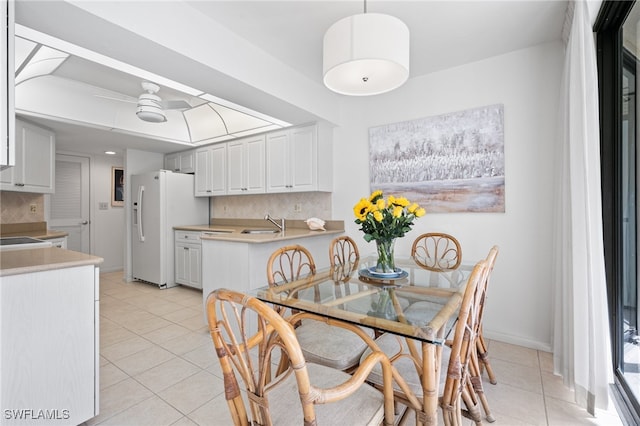 dining space featuring sink, ceiling fan, and light tile patterned flooring