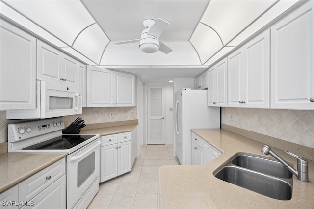 kitchen with sink, white appliances, light tile patterned floors, tasteful backsplash, and white cabinets