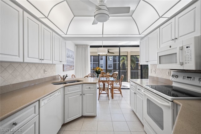 kitchen with white appliances, light tile patterned floors, sink, and white cabinets