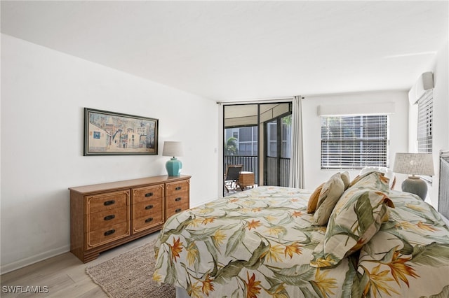 bedroom with access to exterior and light hardwood / wood-style floors