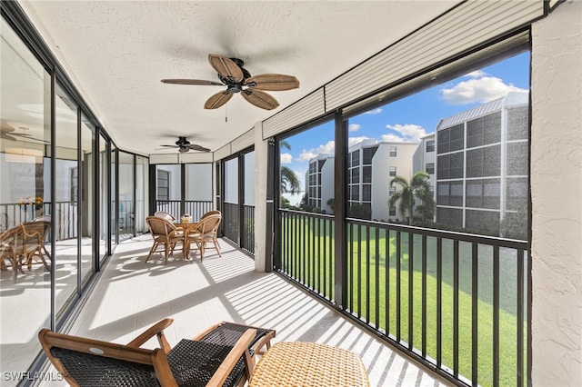 sunroom / solarium featuring ceiling fan