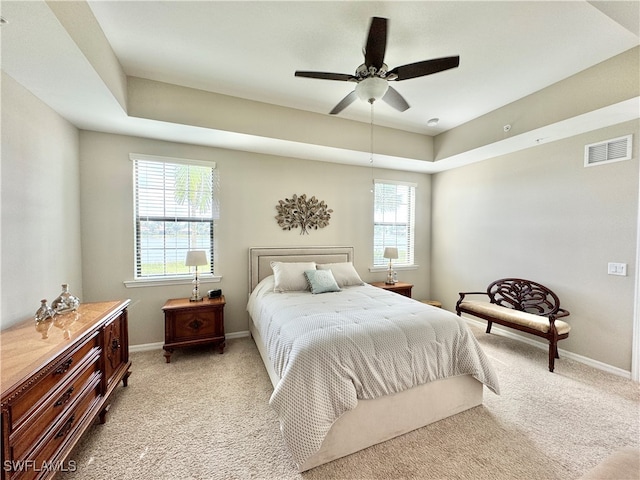 bedroom featuring ceiling fan, multiple windows, and light carpet