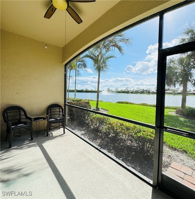 sunroom featuring a water view and ceiling fan