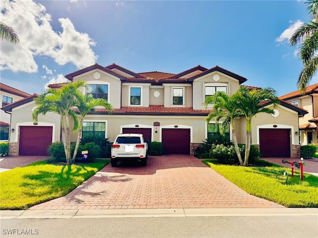 mediterranean / spanish home with a garage and a front yard