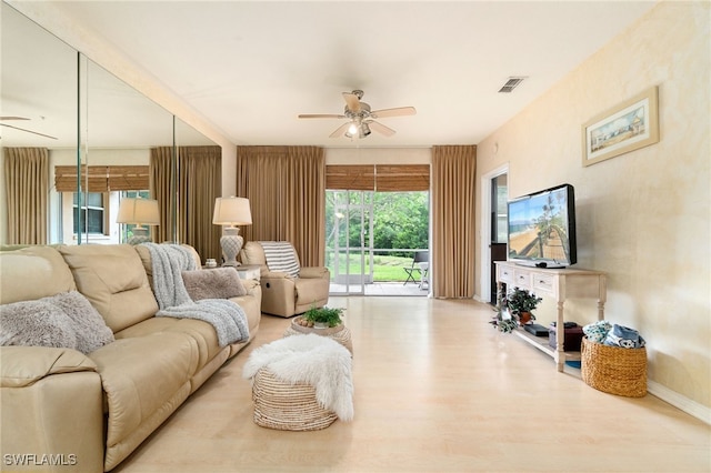 living room featuring light hardwood / wood-style flooring and ceiling fan